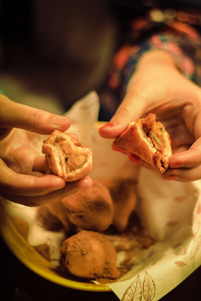 Delicious samosas being shared and enjoyed, highlighting the cultural cuisine of Dhaka, Bangladesh.
